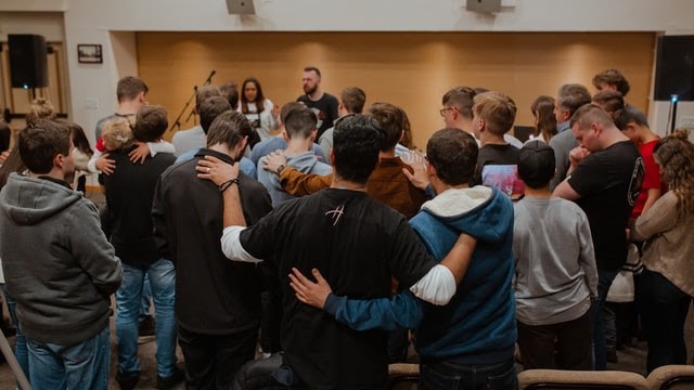 High school students engaged in classroom prayer