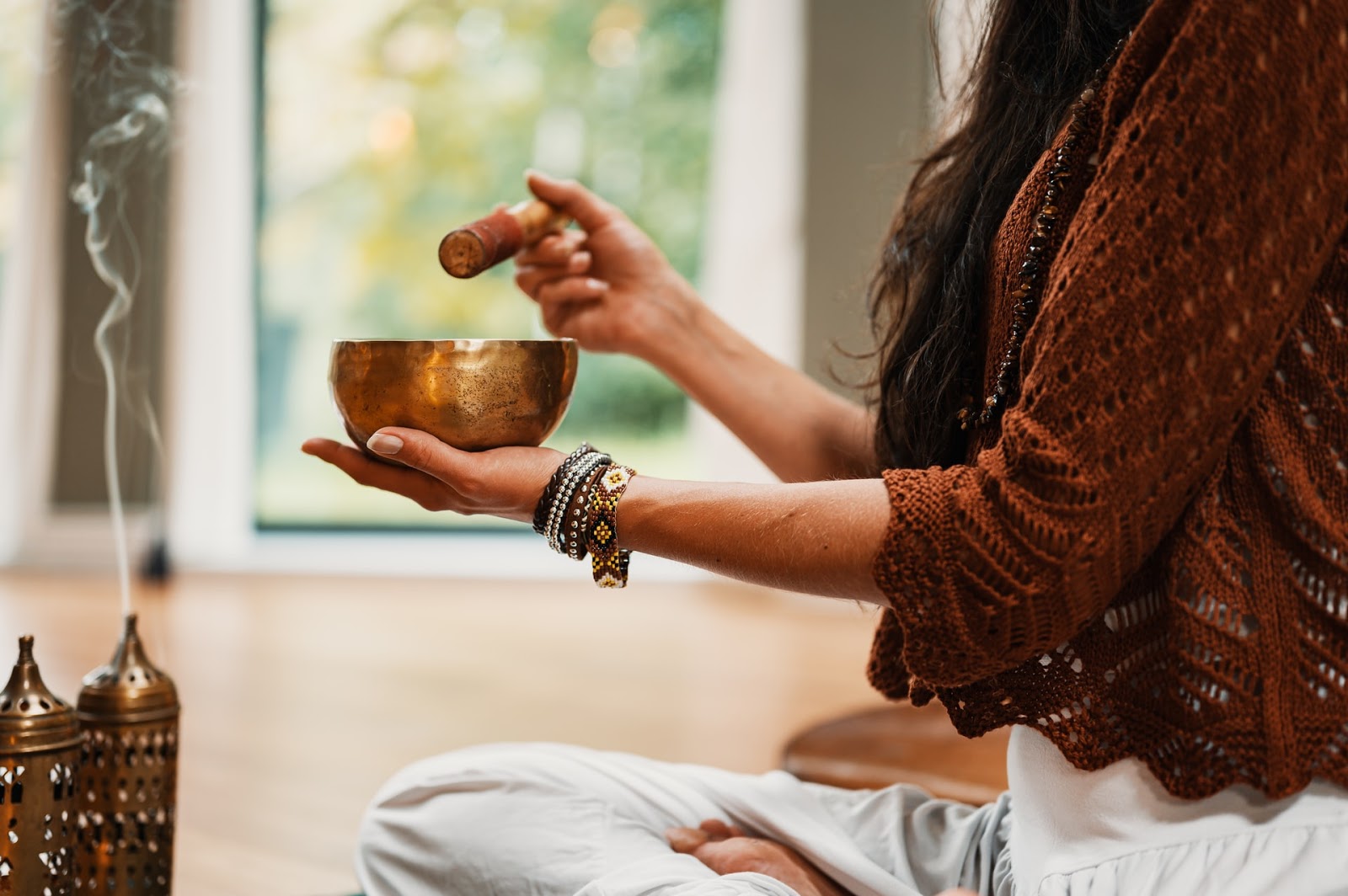 a woman holding a brass singing bowl