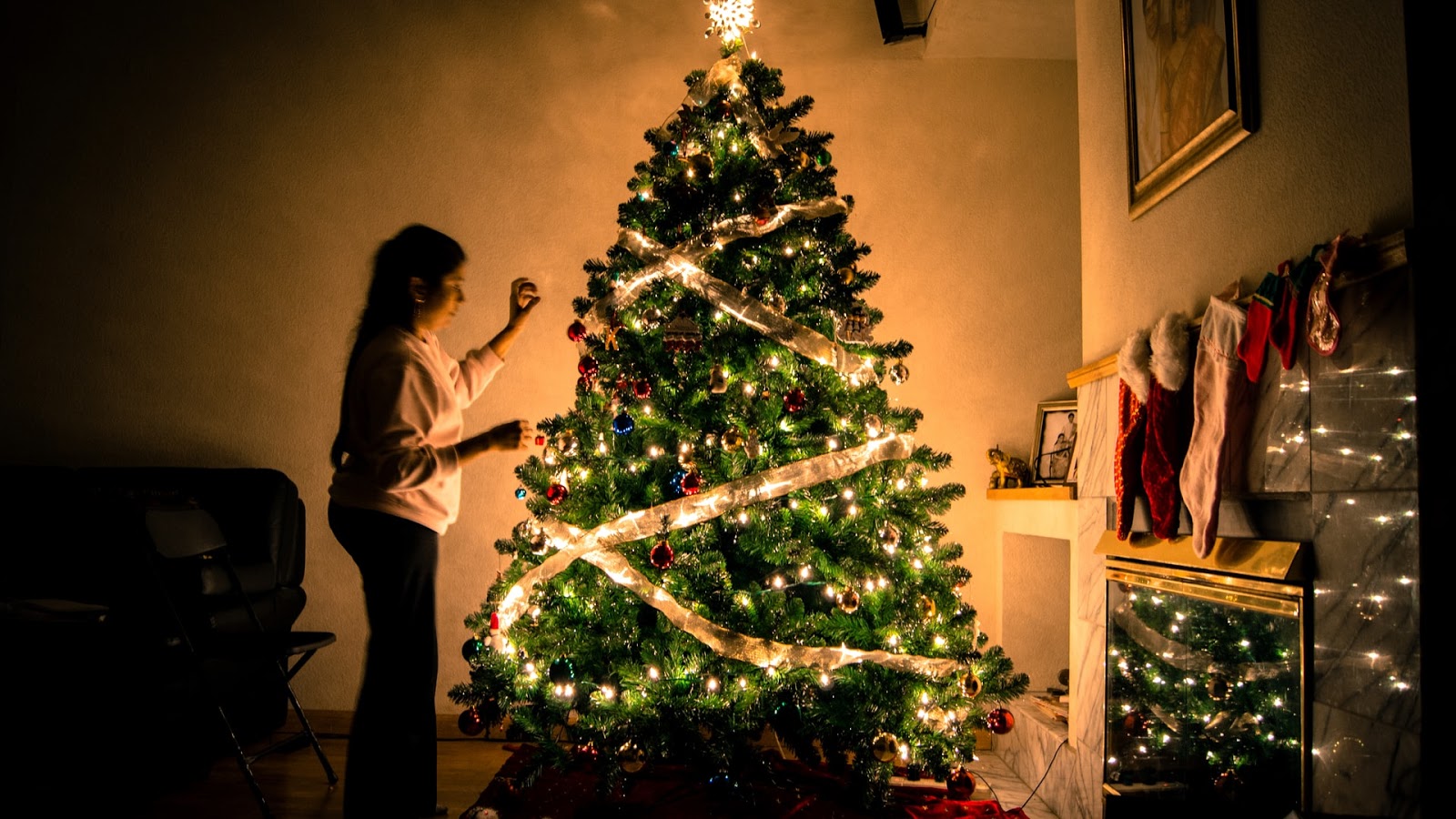  a girl decorating a Christmas tree