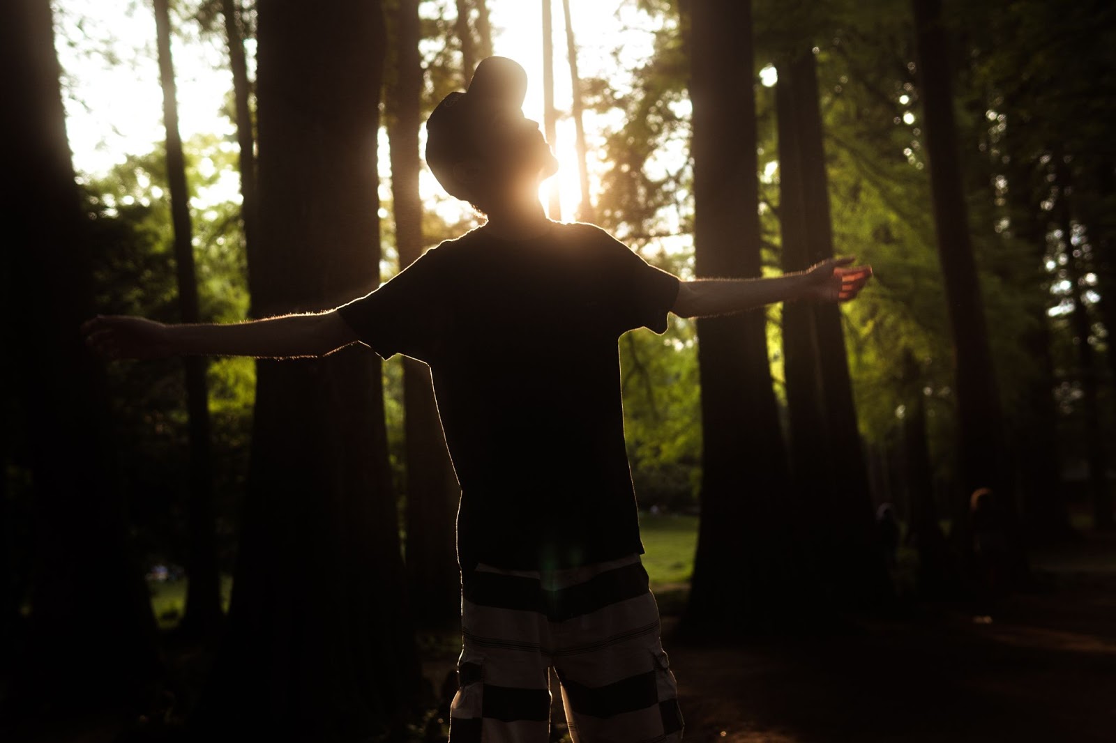 Man standing outside with arms stretched toward heaven.