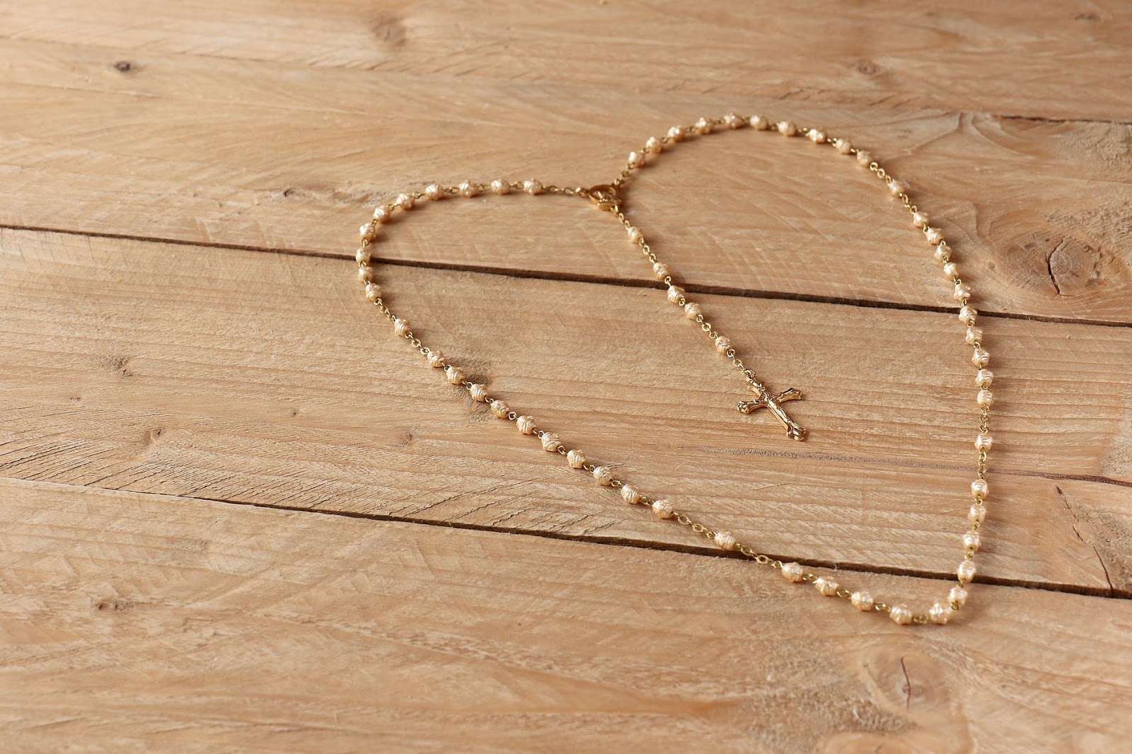 Cross necklace laid in the shape of a heart