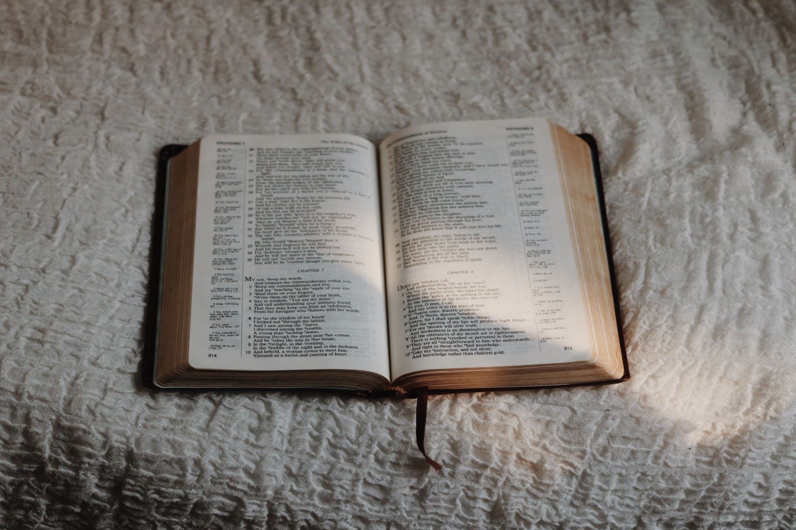 Bible sitting open on a bed