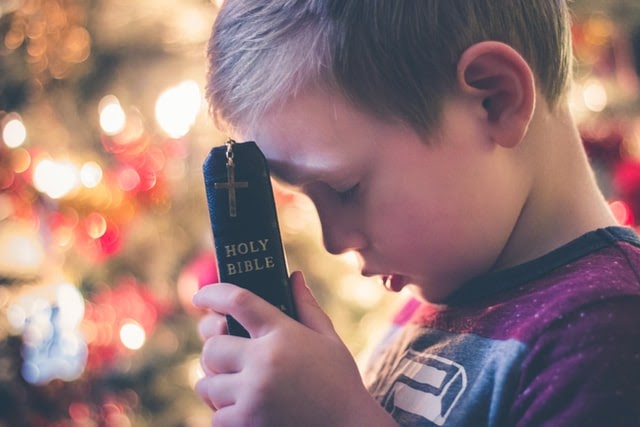 Young boy holding a Bible close