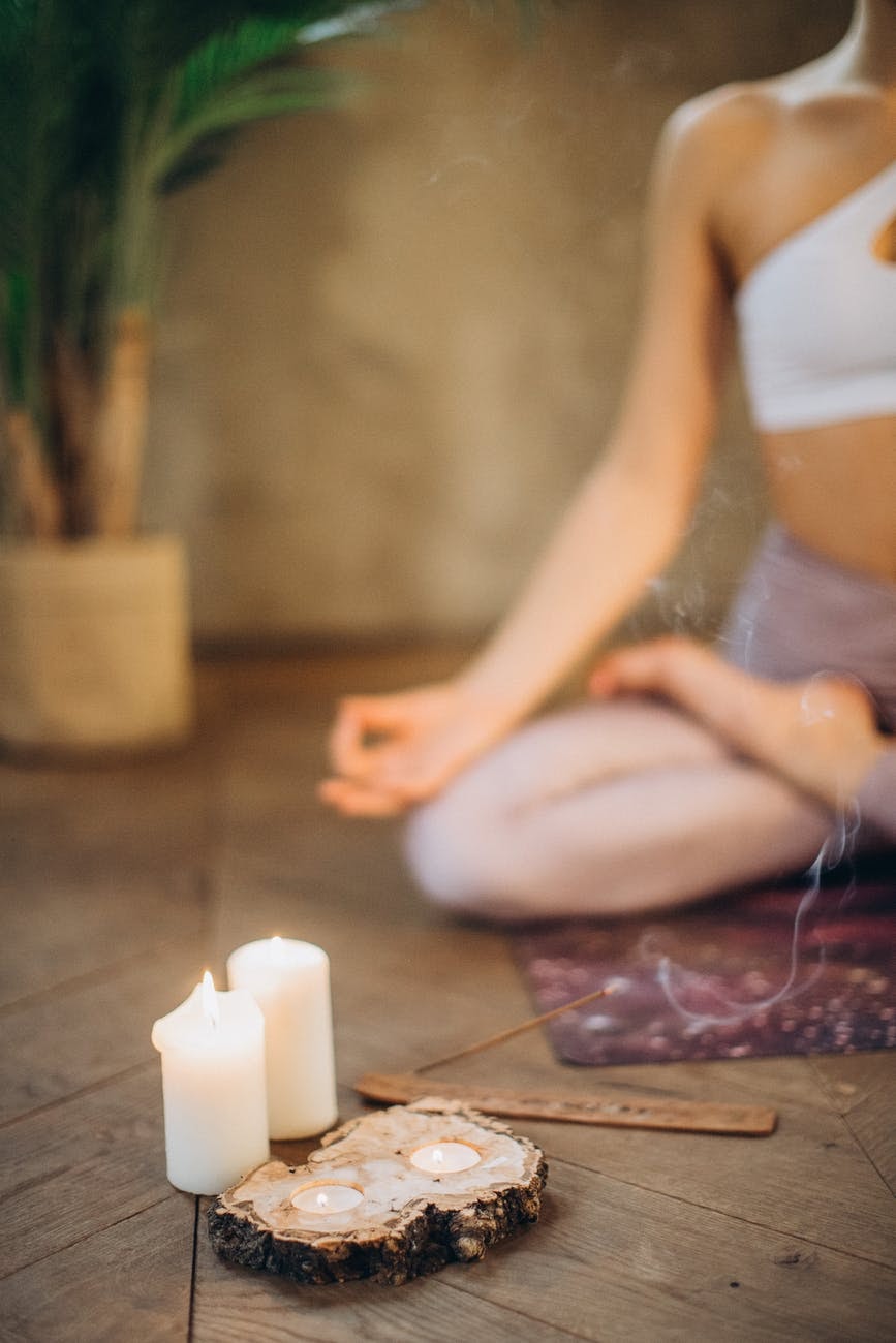 Woman meditating with candles and incense