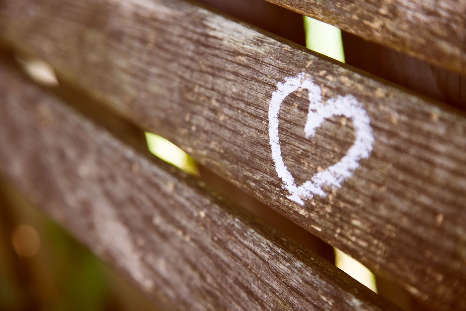 A white heart drawn on a wooden bench