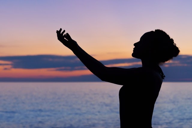 Woman meditating at dawn
