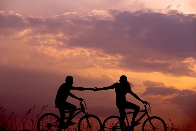 Loving couple cycling at sunset