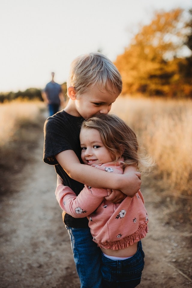 Family love - small boy hugging his sister