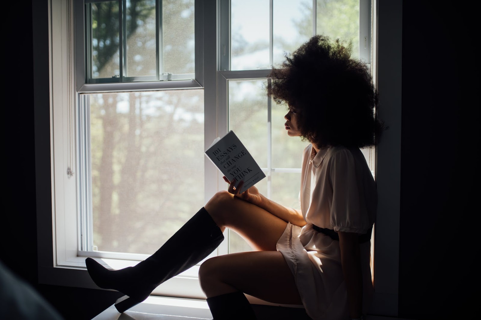 Woman reading alone on a windowsill