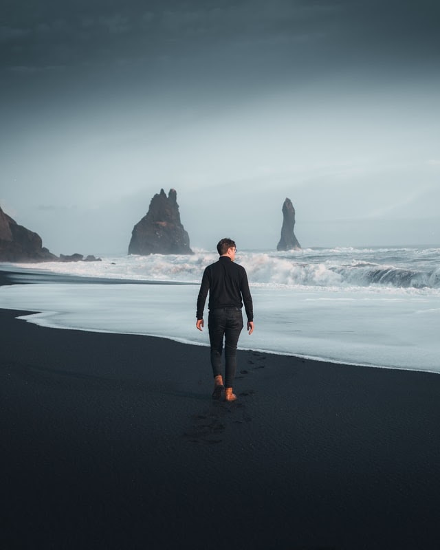 Man walking on beach barefoot