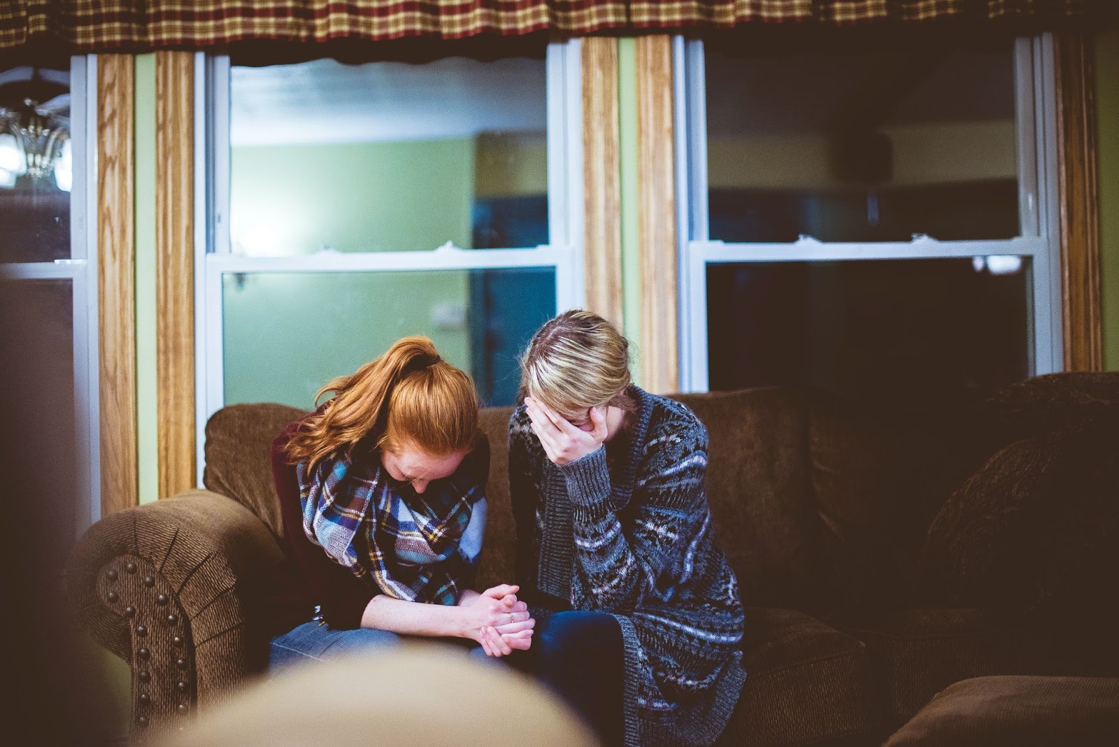 Women holding hands in distress