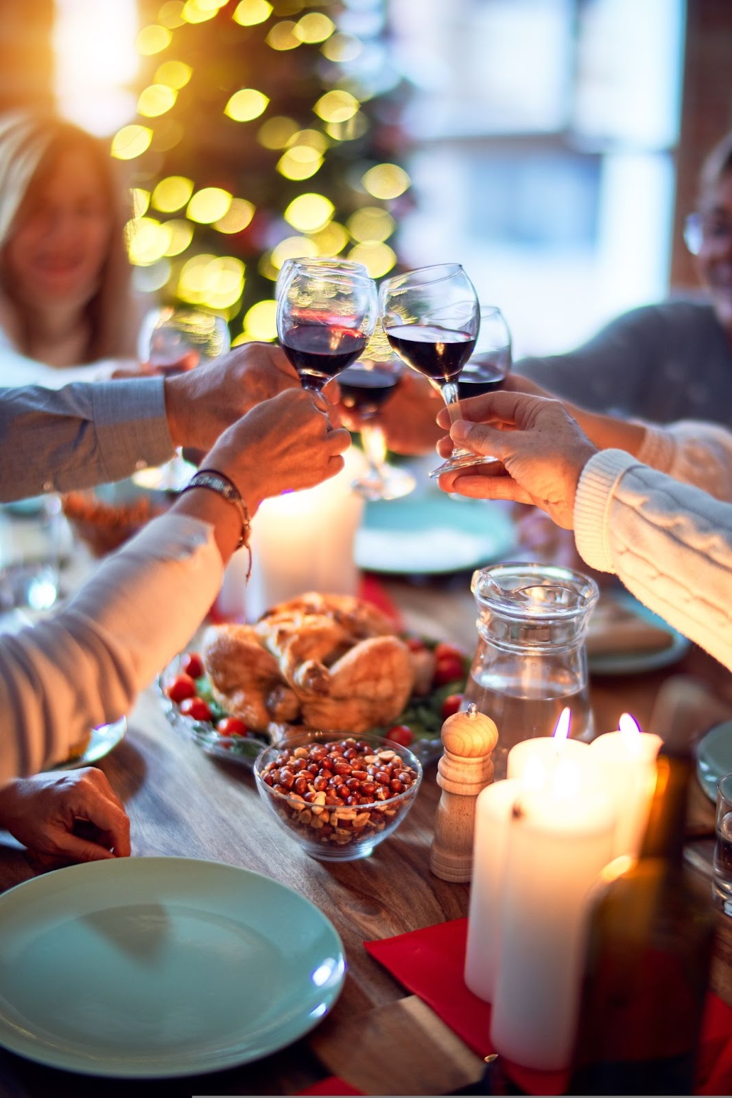 a group of people at a dinner table cheering their wine glasses together