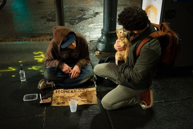 Young man talking to homeless man