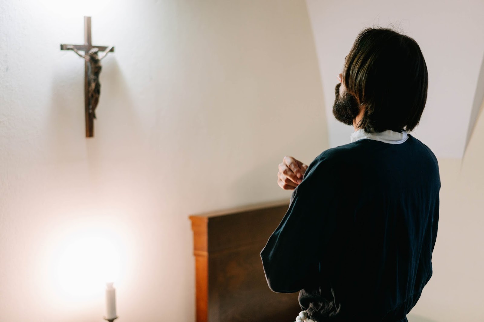 Man praying in front of crucifix