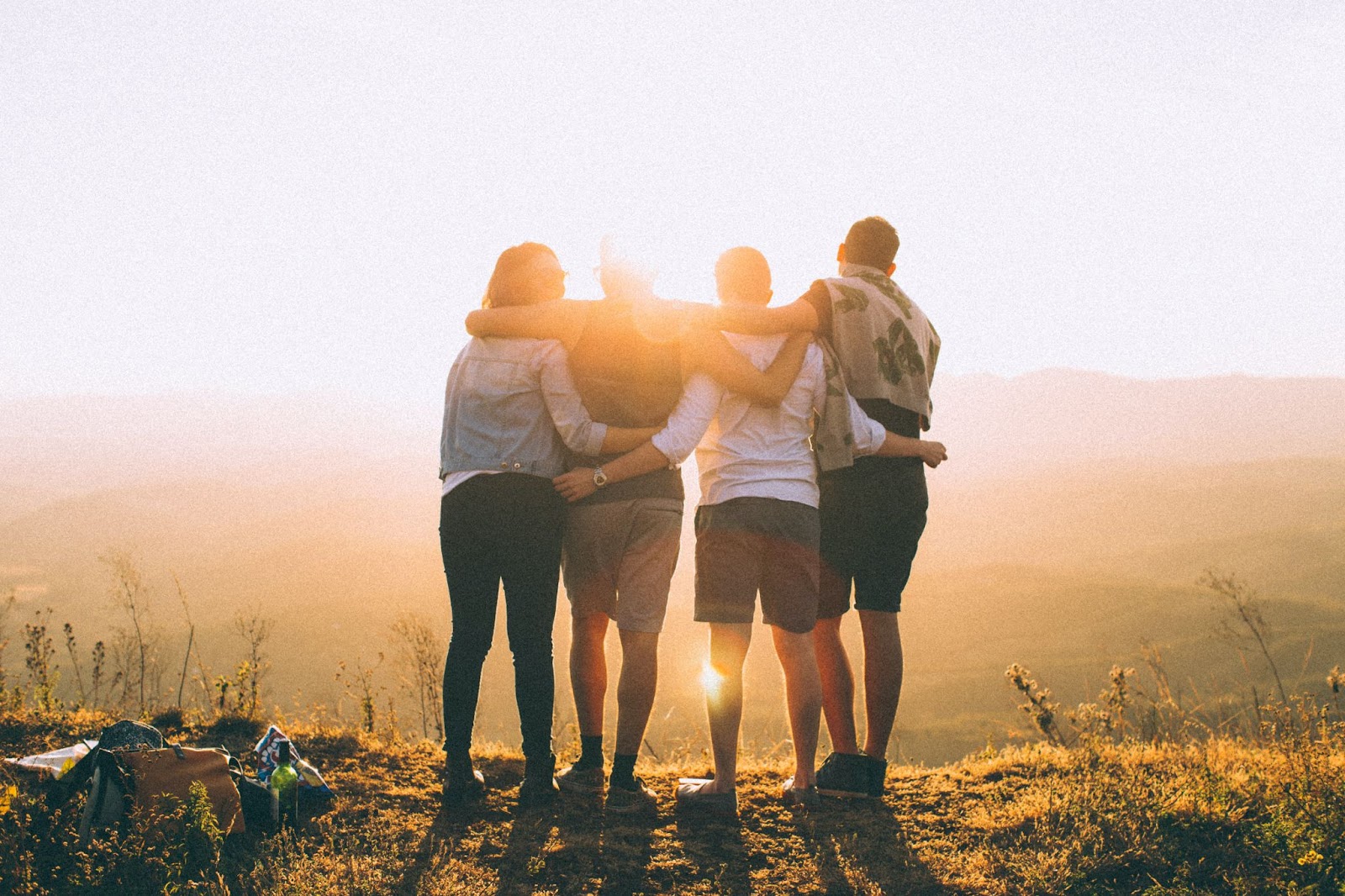 Four people with their arms wrapped around each other