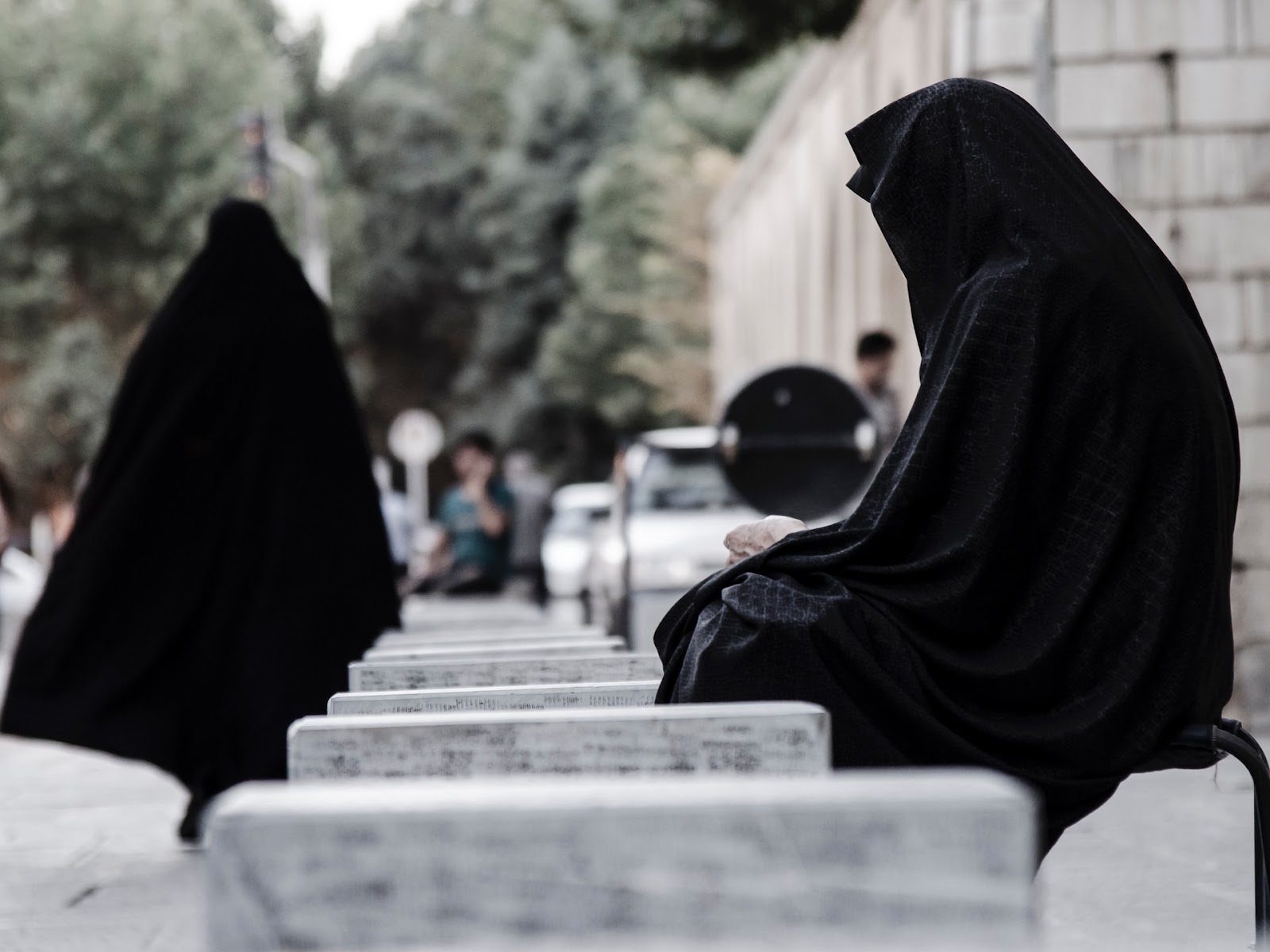 a woman in a veil watching another woman walk away