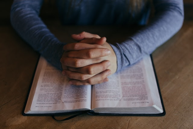 Person praying over Bible