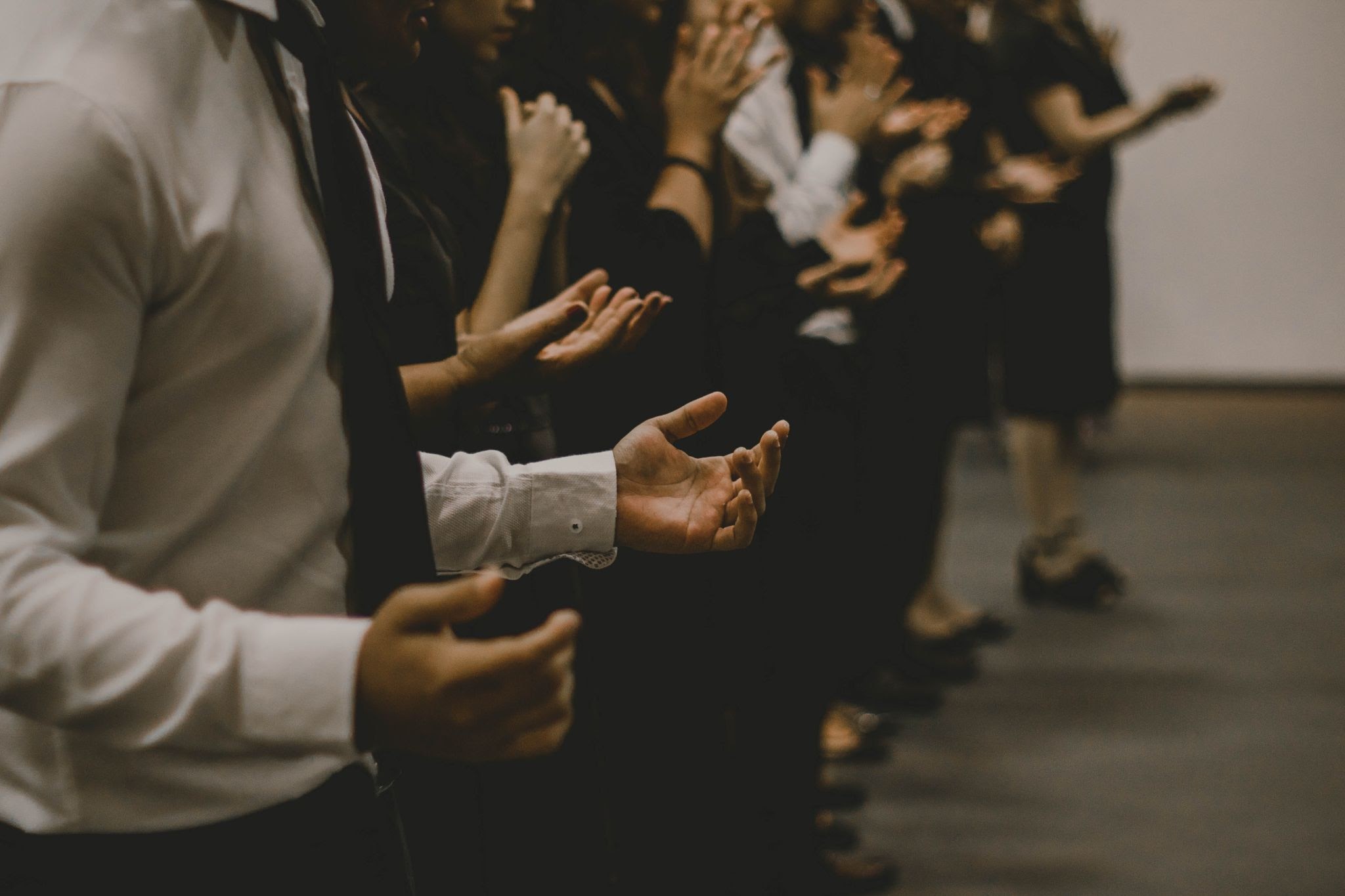 People praying with hands facing the ceiling