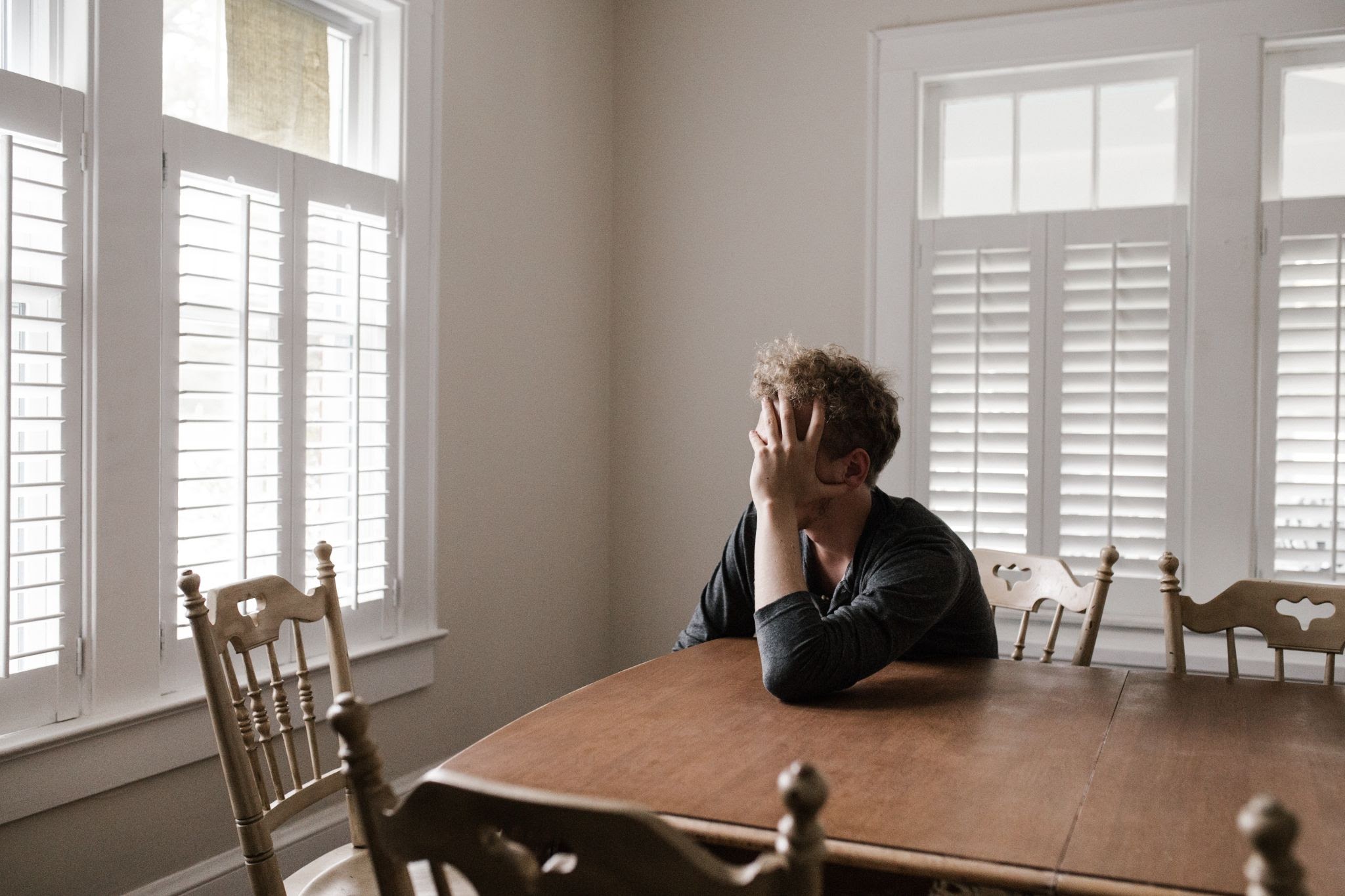 Depressed man with head in hand