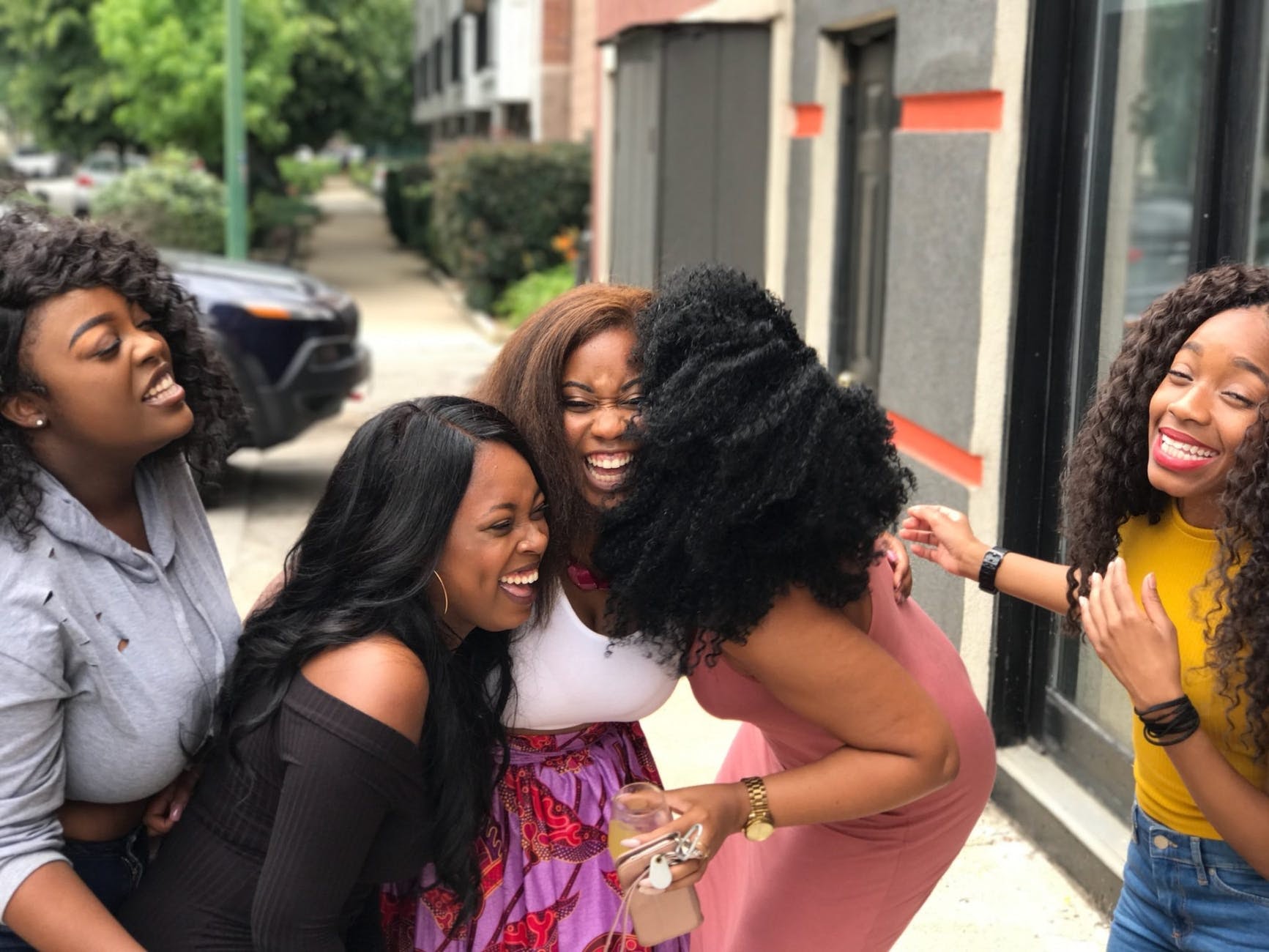 Five women smiling together outside