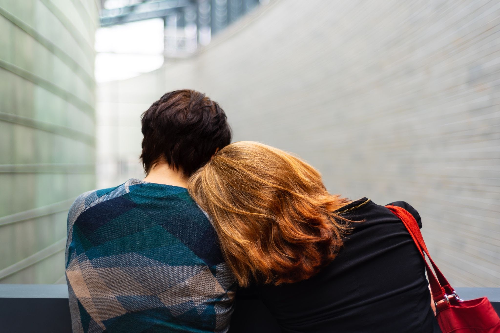 person lays their head on someone else's shoulder