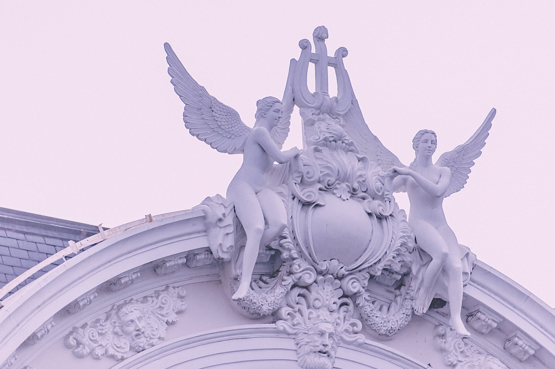 Two female angel statues on top of building
