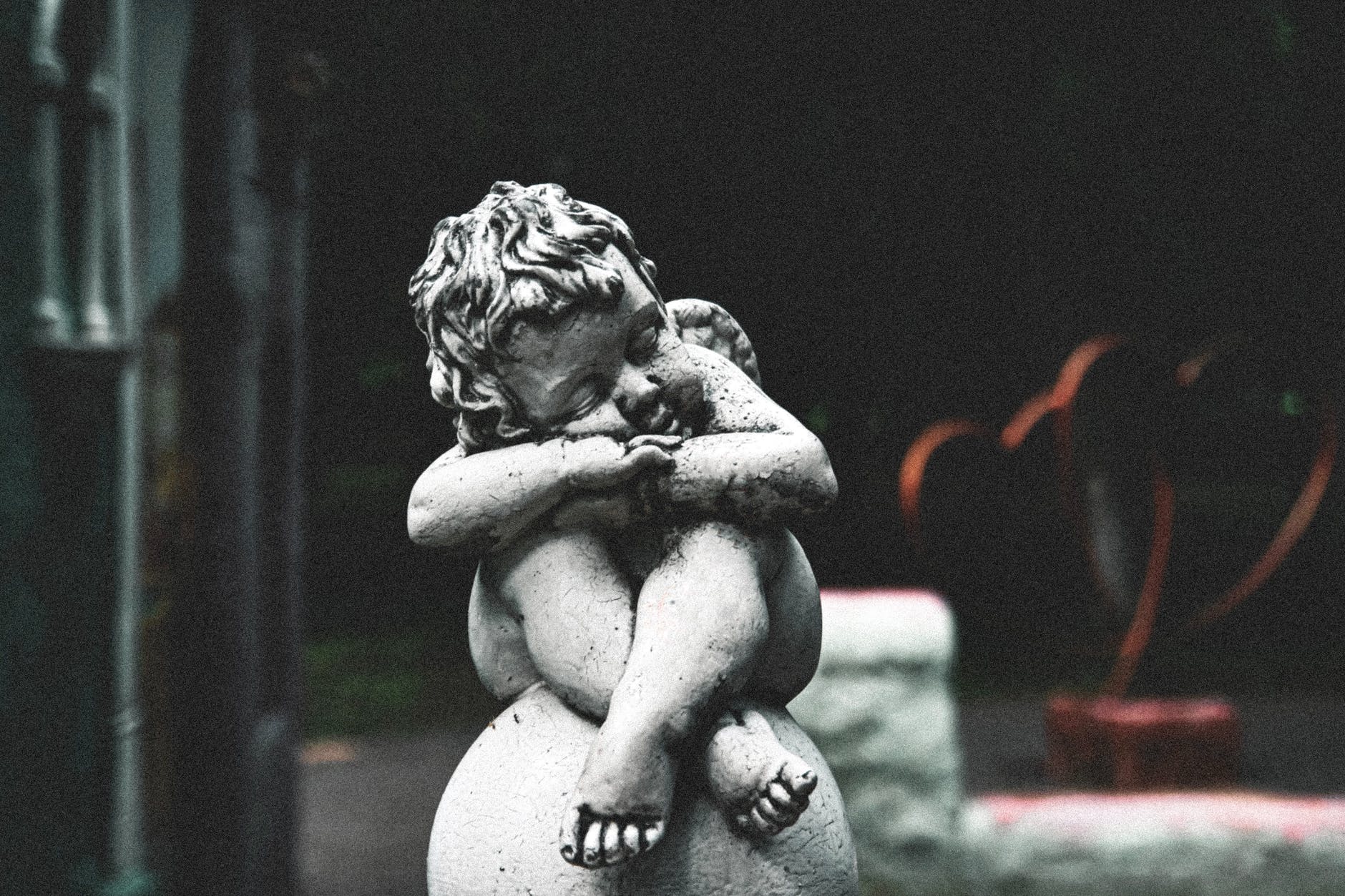 Baby angel statue with legs crossed