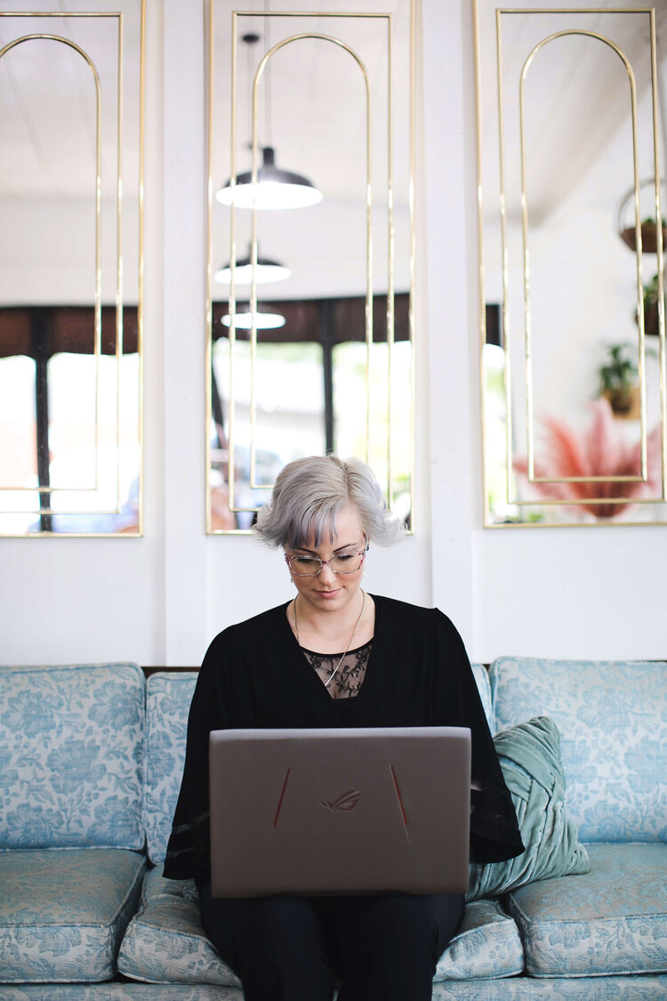 Danielle Wayne, a Boise therapist, types on her computer while sitting on a couch.