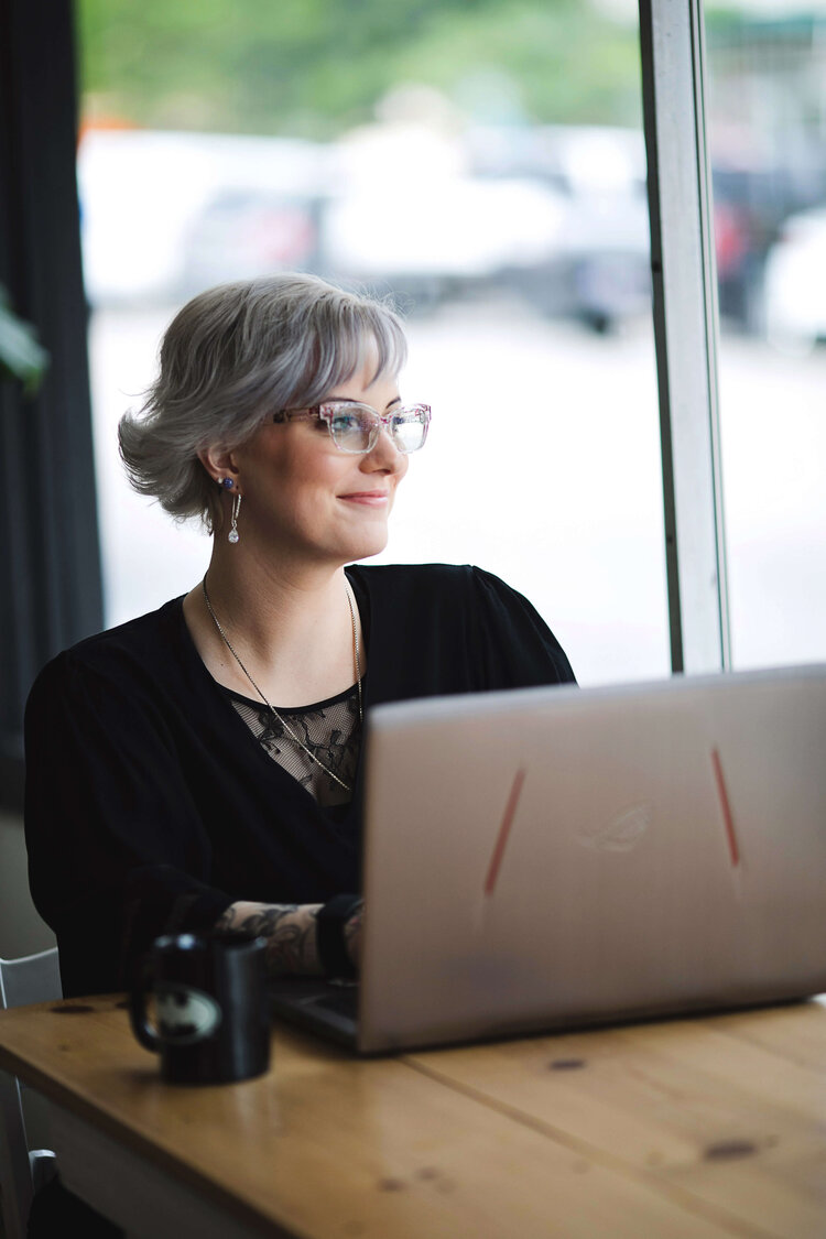 Danielle Wayne, an online anxiety therapist in Boise, replies to clients on her laptop while looking out a window.