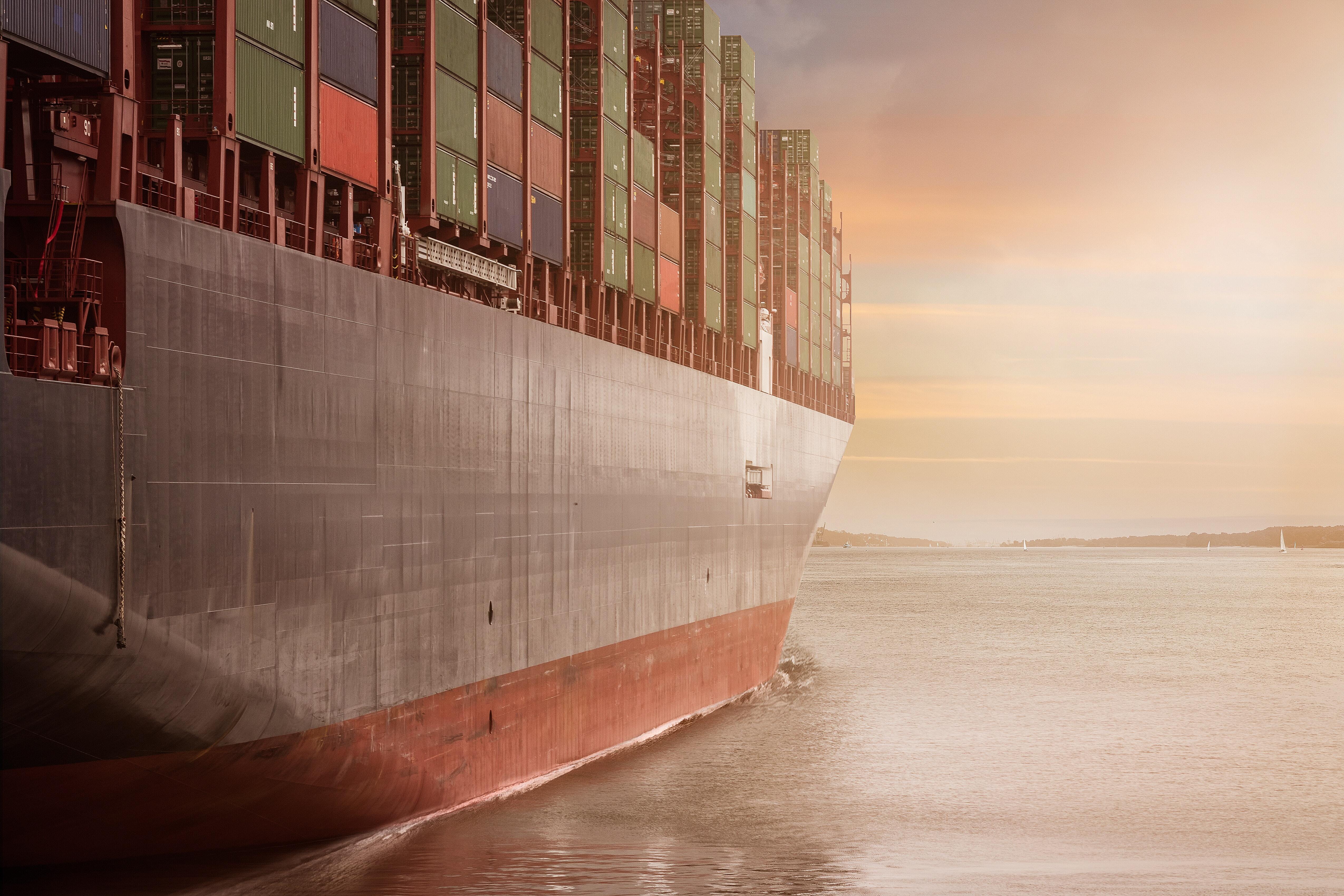 Vessel travelling in sea carrying containers on a bright sunny morning