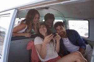 A group of people smiling while using interactive content on a phone.