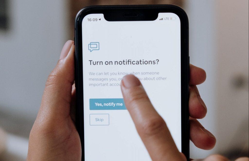 A person setting up notifications on their phone.