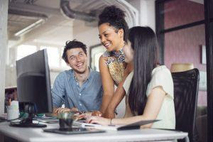 People smiling while looking at stories on a computer showing why you need to use story content for eCommerce marketing.