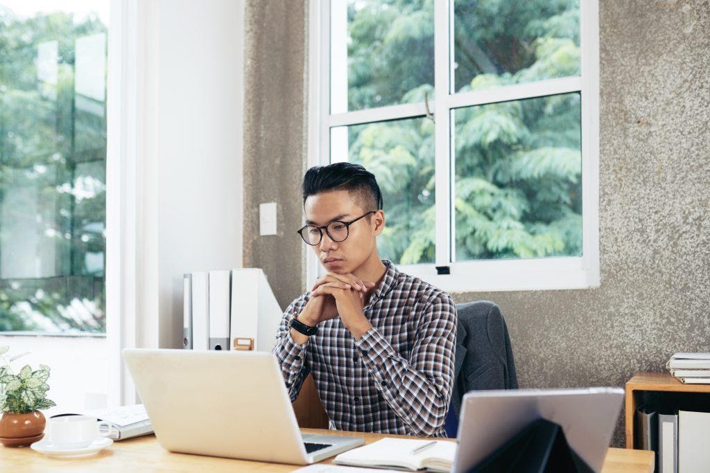 A person reading an article on their laptop.