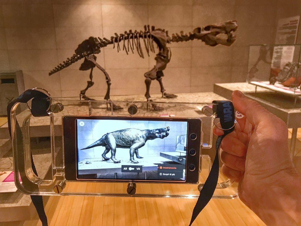 A person using an AR program on their phone to view a museum exibit.