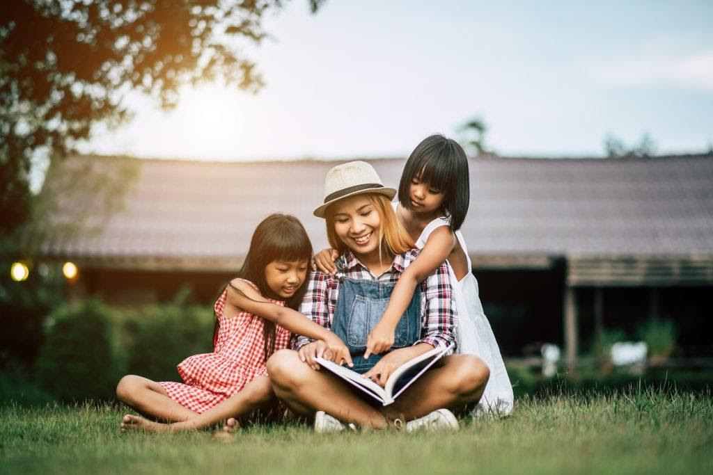 A mother reading a story to her kids.