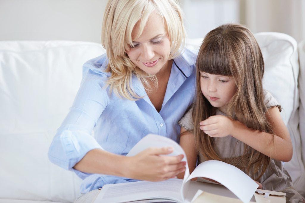 A mother reading a story book with her child.