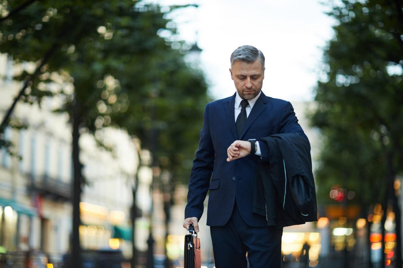 A person in professional attire checking their clock.