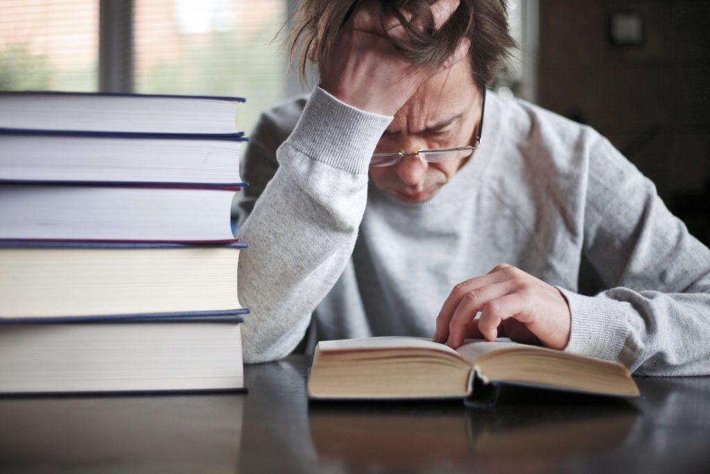 A person feeling emotional while reading a book.