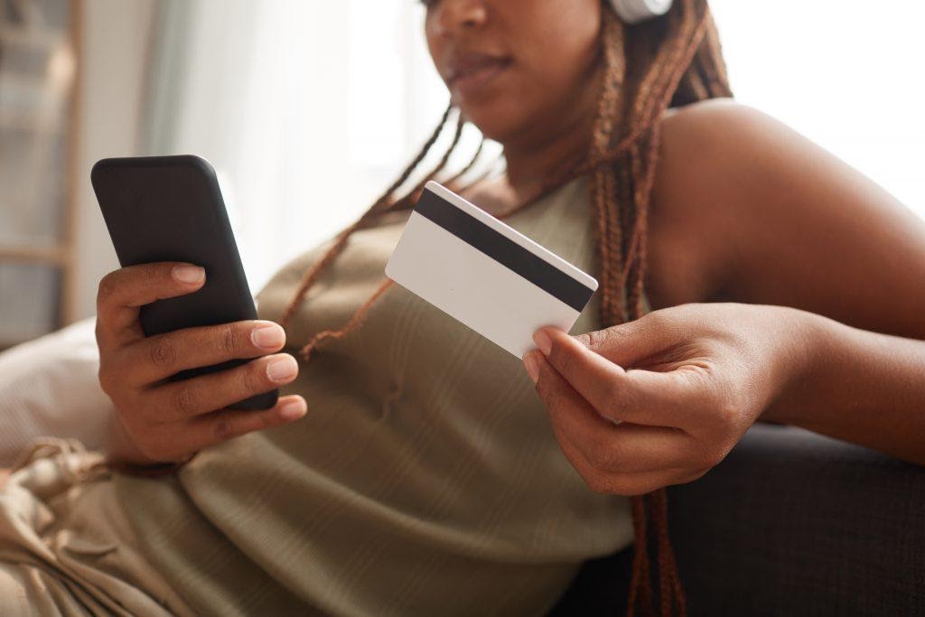 A woman using her phone to purchase something, showing a connection between Shopify and mobile stories.