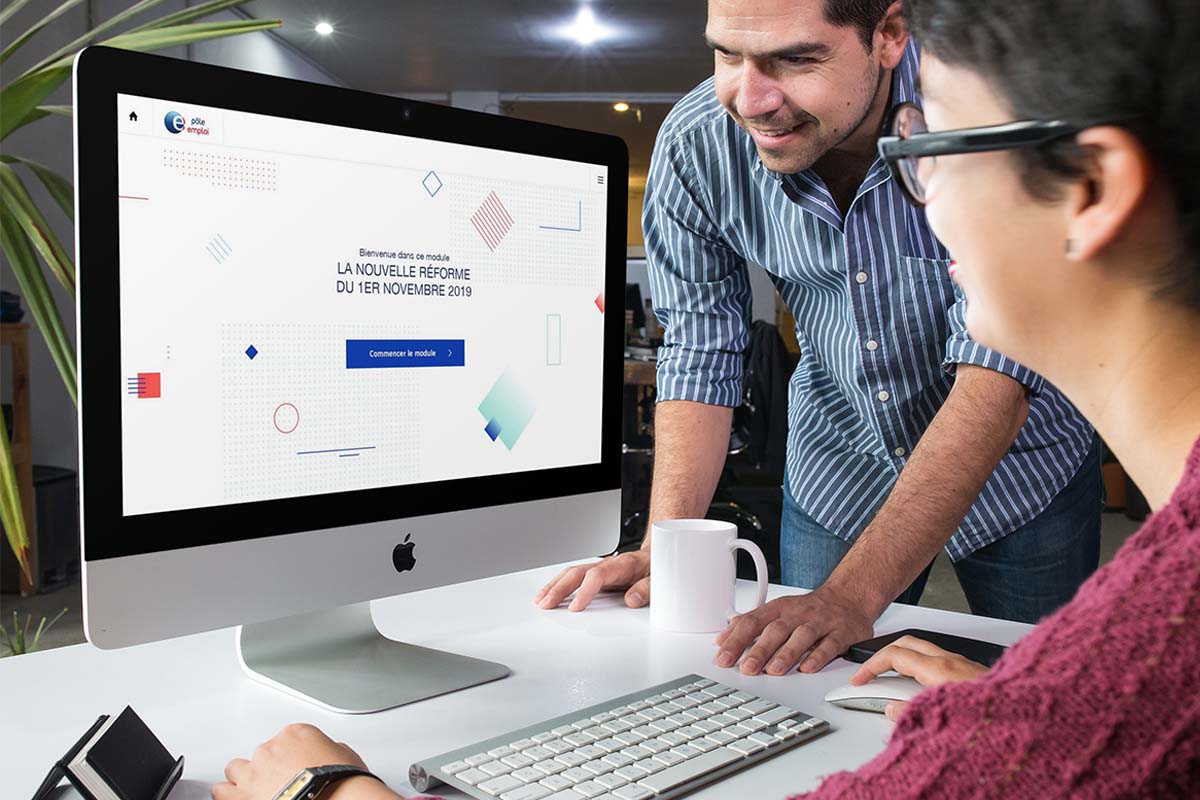 Deux employés de Pôle Emploi lancent la formation “La nouvelle réforme du 1er novembre 2019” sur leur ordinateur de bureau.