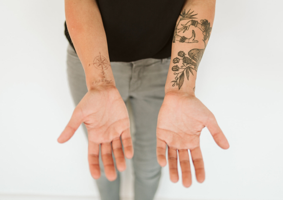 Mary Burn's hands, tattooed with Hawaiian massage symbols.