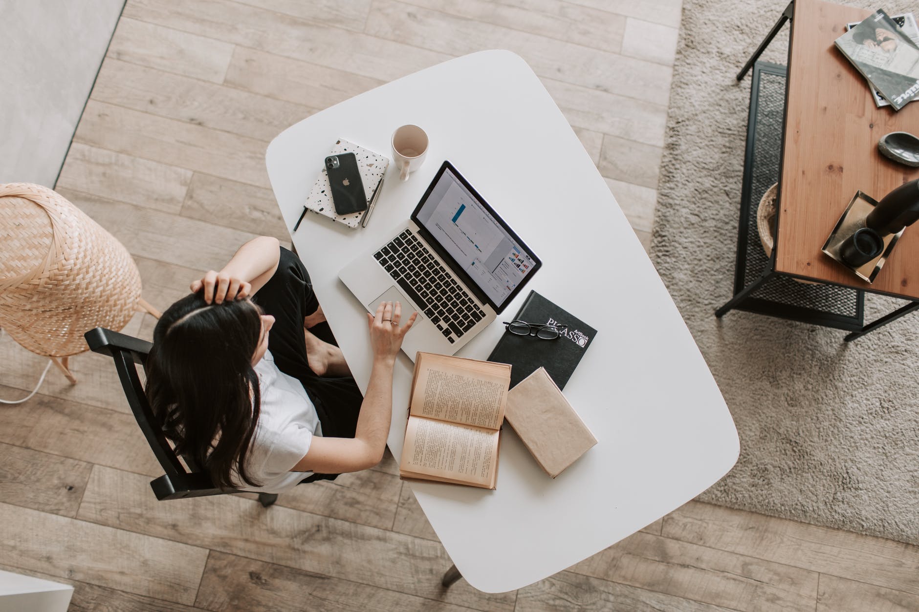 Wanita menggunakan laptop di atas meja putih