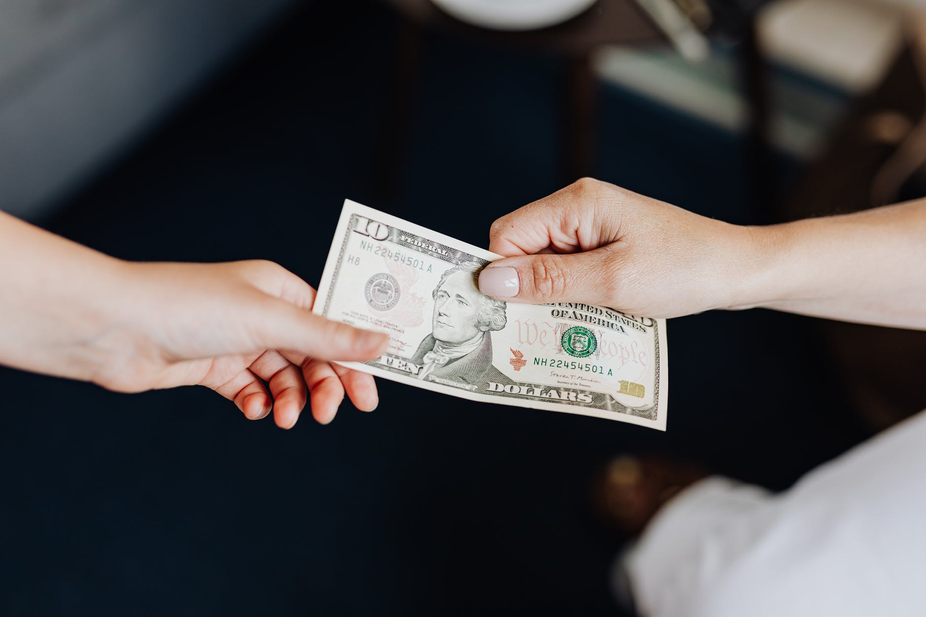 Dua tangan memegang uang kertas dolar