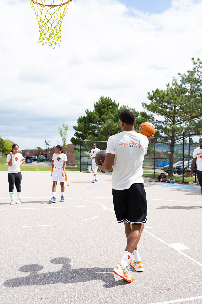 Volunteer helping with basketball shooting drills