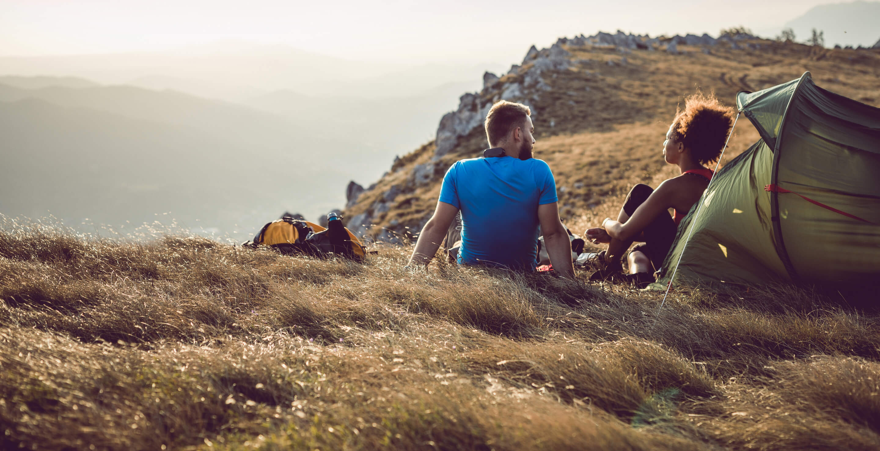 A couple camping atop a high dessert mountain