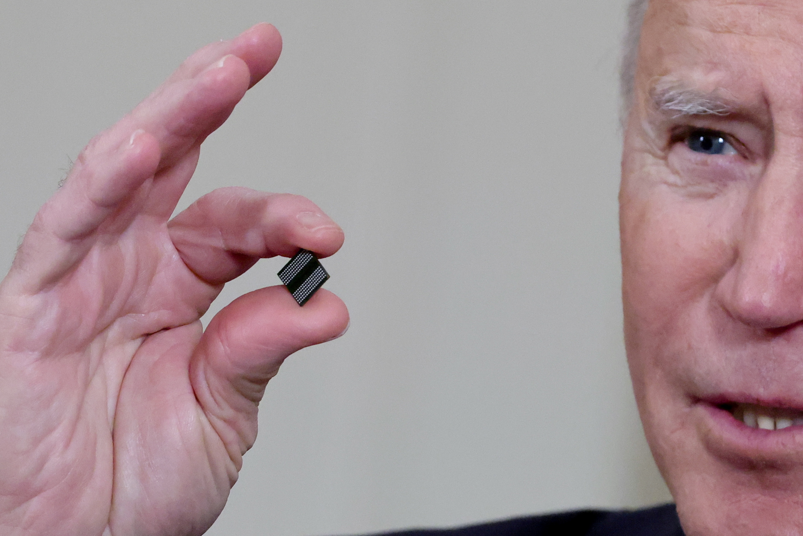 U.S. President Joe Biden delivers holds a semiconductor chip as he speaks prior to signing an executive order, aimed at addressing a global semiconductor chip shortage, in the State Dining Room at the White House in Washington, U.S., February 24, 2021. REUTERS/Jonathan Ernst/File Photo/File Photo