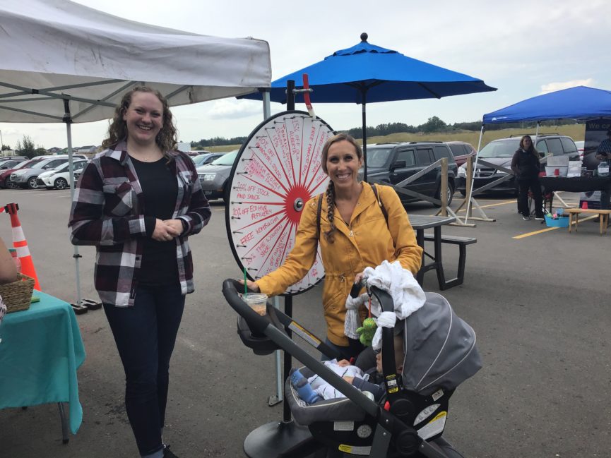 Two people in front of the prize wheel
