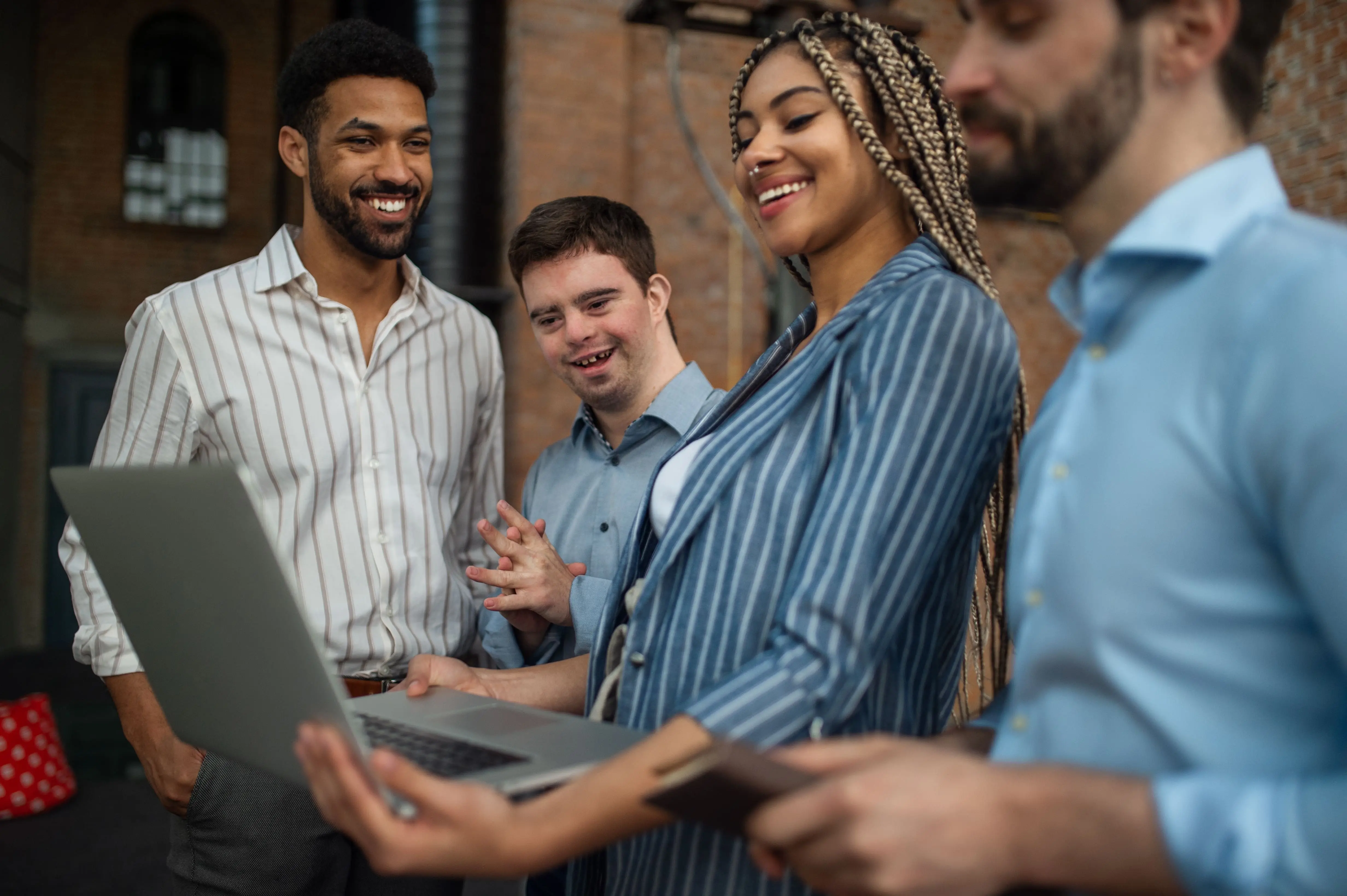 Team of office workers around a laptop