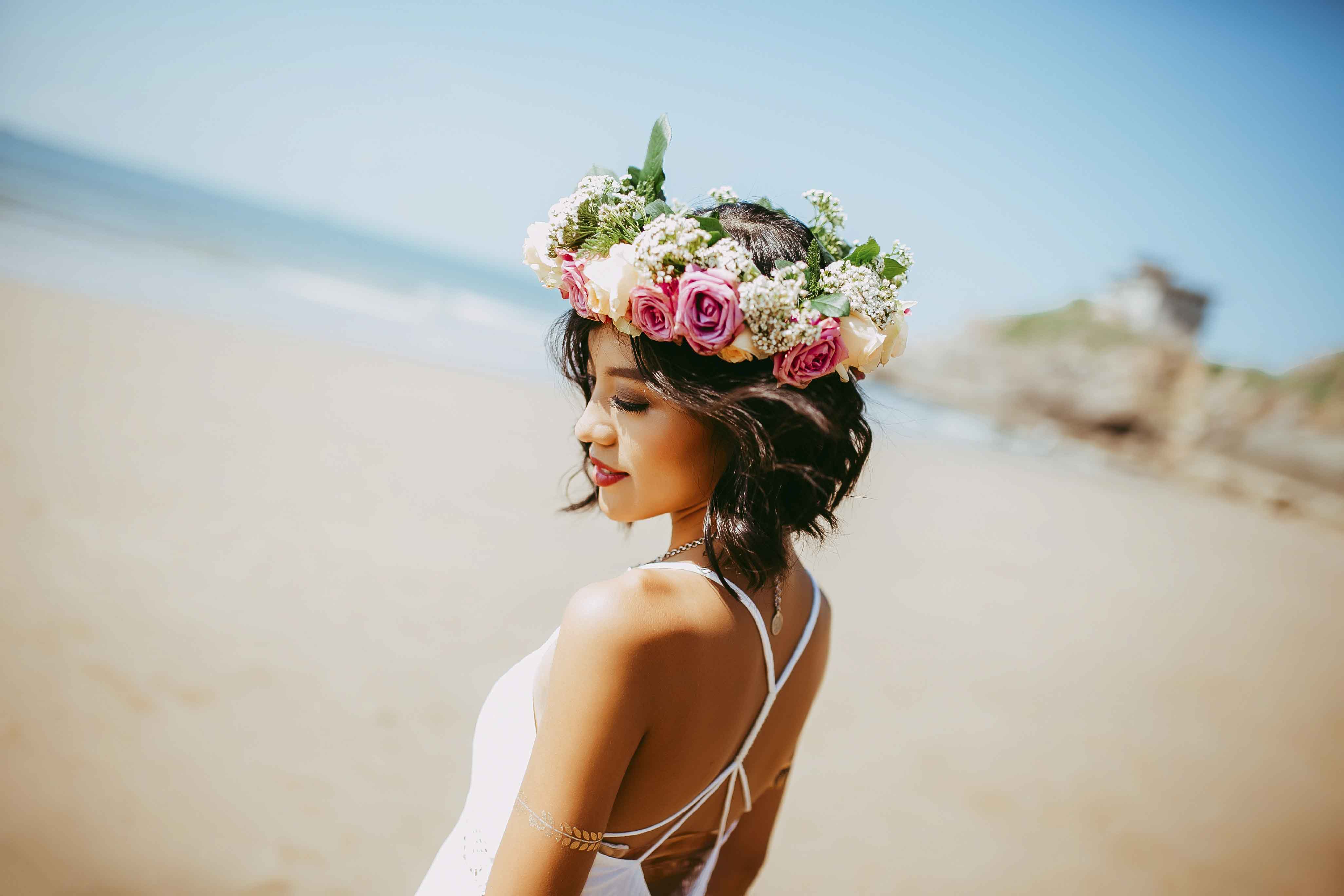 Woman in a flower crown on the beach.
